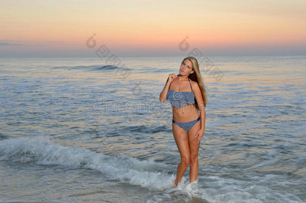 日出时海滩上的泳装模特
