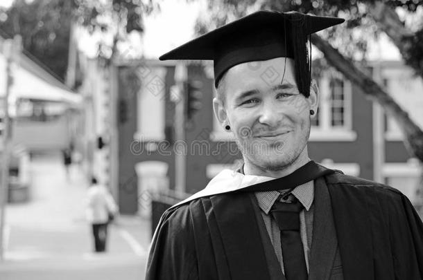 年轻兴奋紧张的男子大学毕业典礼上戴帽子