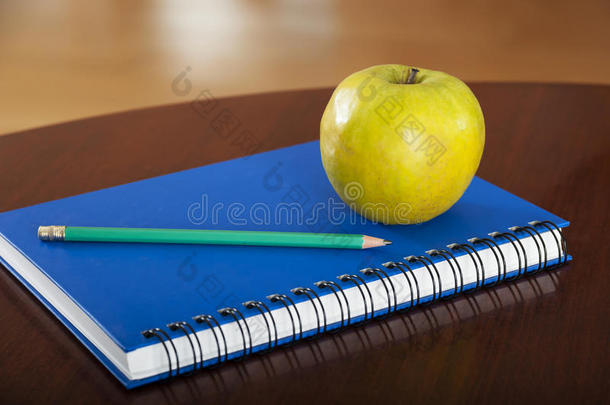 木桌上放着苹果的学习用品