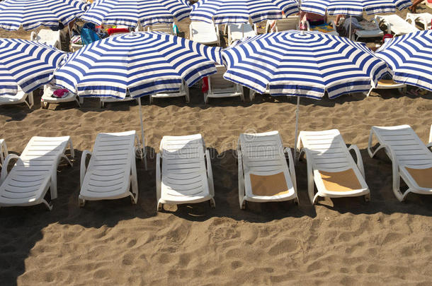 条纹沙滩伞和白色日光浴床