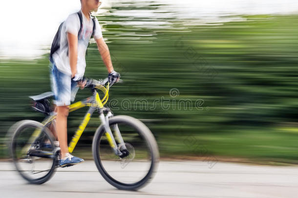 在城市道路上骑车的男孩