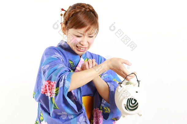 年轻女子穿着日本和服，带<strong>蚊香</strong>，被蚊子叮咬