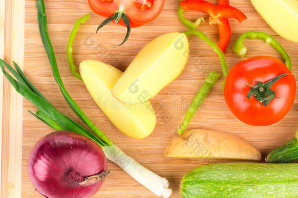 各种成熟的蔬菜放在砧板上。