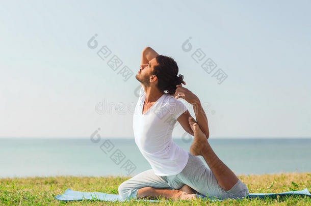 微笑的男人在户外做瑜伽练习