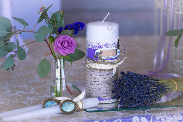 紫色婚礼桌装饰。鲜花和蜡烛。年份酒。一束薰衣草。