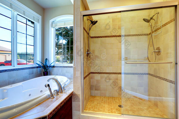带漩涡浴缸和玻璃<strong>门淋浴</strong>的现代<strong>浴室</strong>