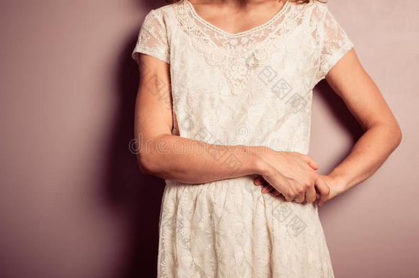 站在紫色<strong>墙边</strong>的一个穿白衣服的年轻女人