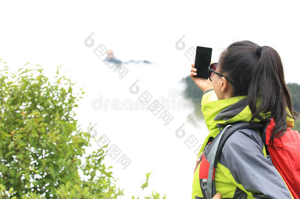 女徒步旅行者用手机拍照