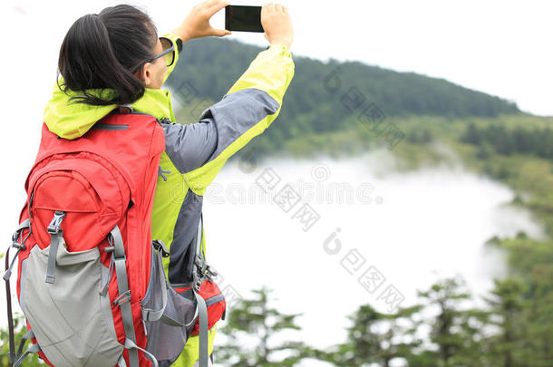 女徒步旅行者用手机拍照