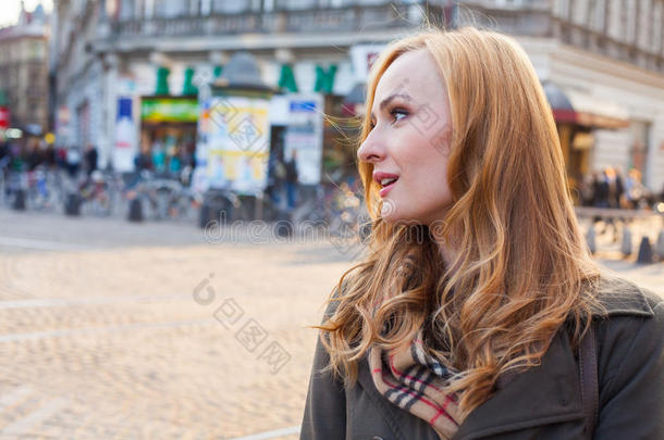 美丽的金发快乐女人走在城市的街道上。户外摄影