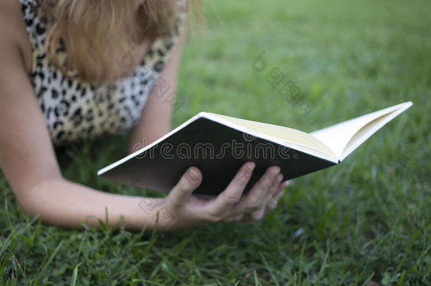 夏天在草地上看书和躺在草地上的女孩