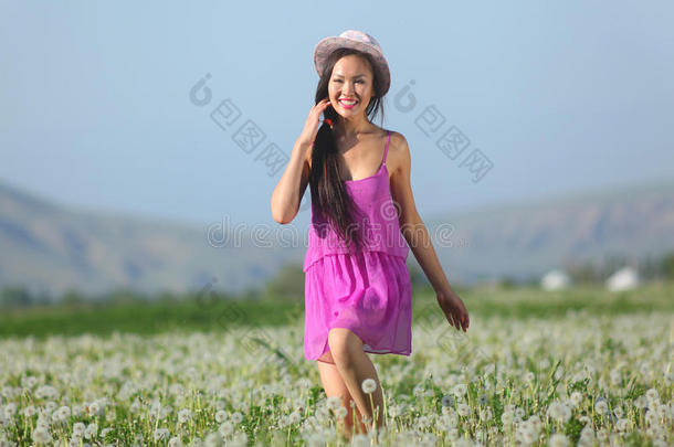 蒲公英地上穿着粉色连衣裙的模特戴着草帽