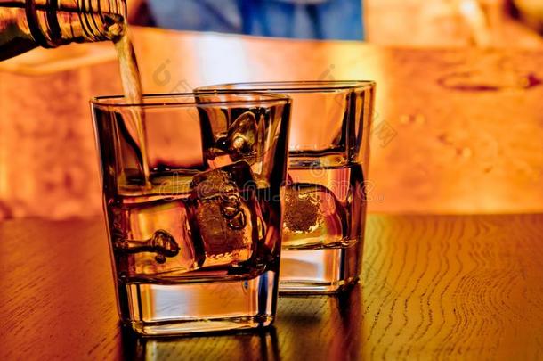 在温暖的<strong>气氛</strong>下，<strong>酒吧</strong>桌上的冰威士忌玻璃杯轮廓