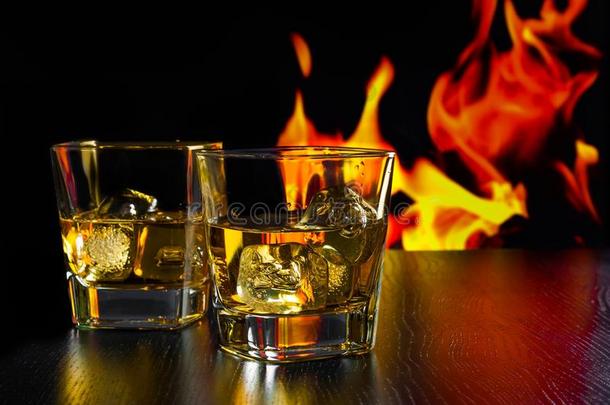 一杯威士忌和冰块放在火焰前