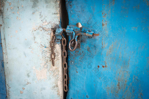 旧的蓝色钢门被铁链锁着