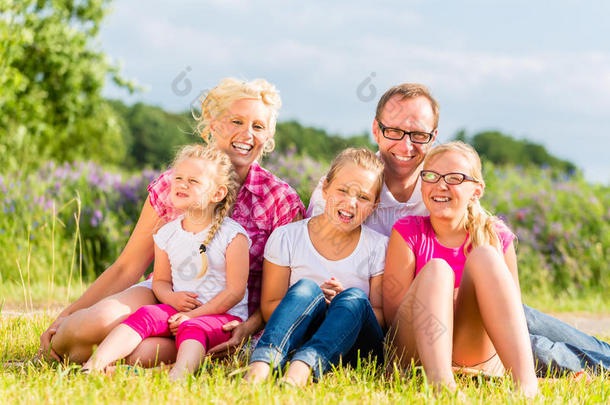 一家人坐在草地或田野上的草地上
