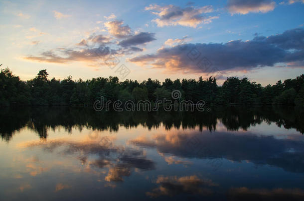 夏日的落日在平静的湖景中重现