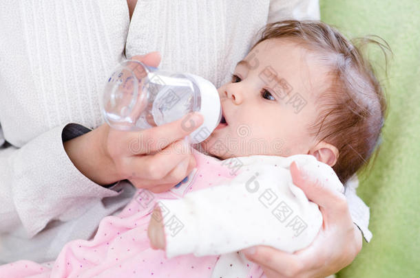母亲用喂养瓶喂养新生女儿