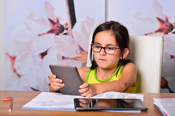 小女孩用平板电脑和电子书做作业