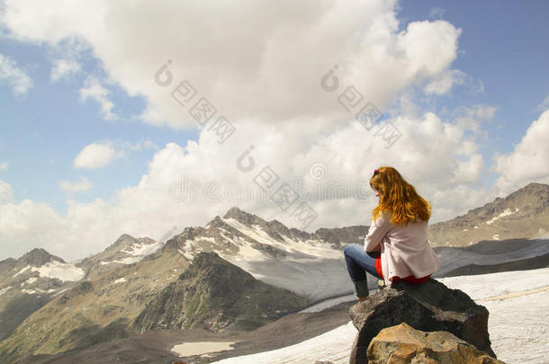 坐在悬崖边上仰望天空的年轻女孩
