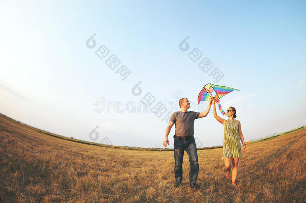 快乐的放风筝的年轻夫妇