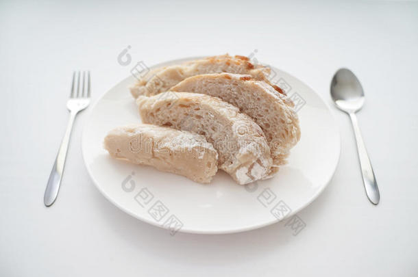 白桌子上有叉子和勺子的面包