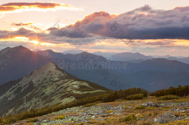 山的全景-日落时间。美丽的山峰，云朵和