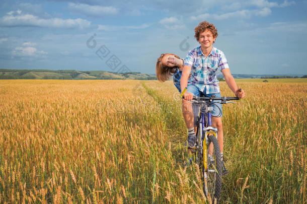 一个少年骑着自行车在麦田里旅行的画像