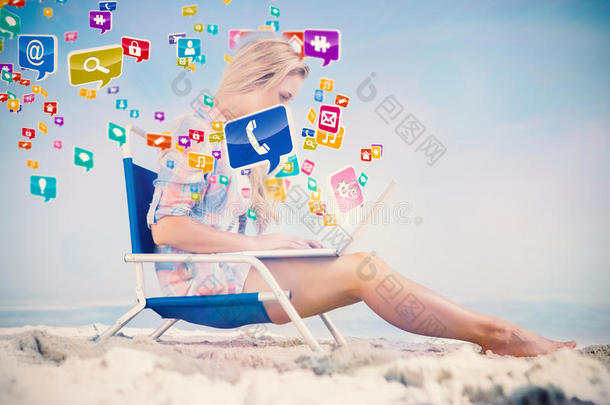 一个金发美女坐在沙滩上用笔记本电脑合成的照片