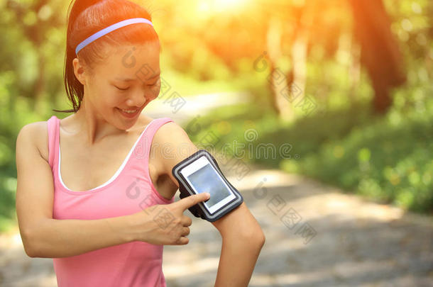 跑步运动员用耳机从智能手机mp3<strong>播放器</strong>收听<strong>音乐</strong>