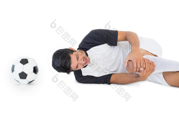 足球运动员躺在地上痛苦地喊叫