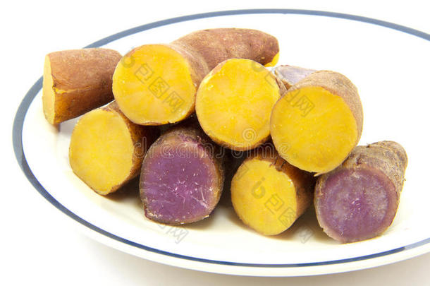 煮过的紫色和黄色的山药在白色的背景下排成一行