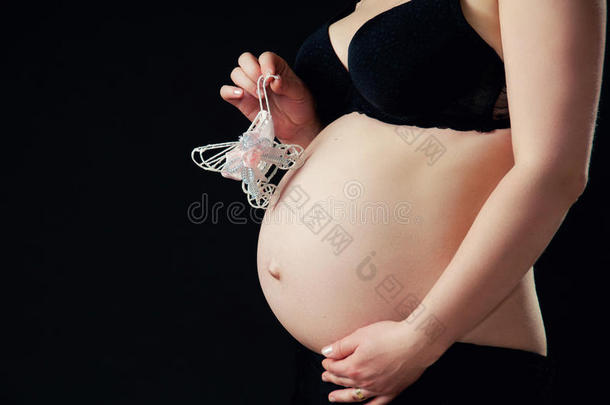 怀孕腹部特写黑色背景。
