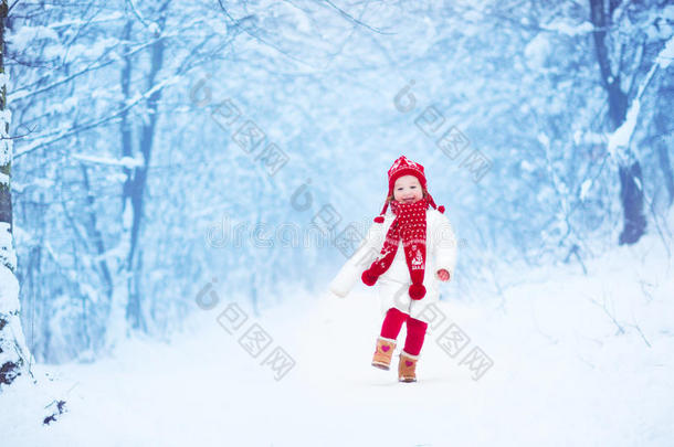 在雪地公园里奔跑的小女孩