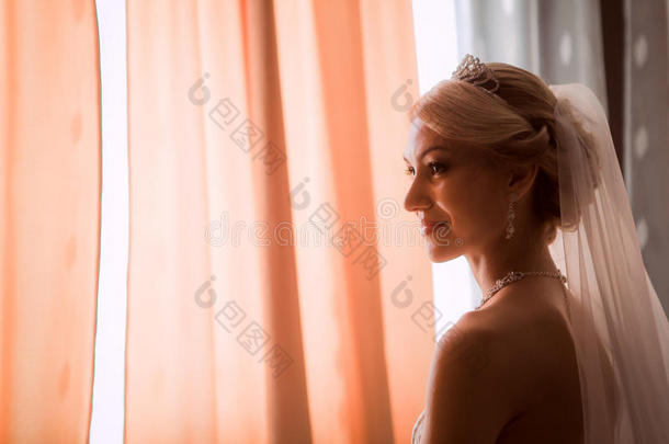 穿着漂亮衣服的新娘靠近窗户