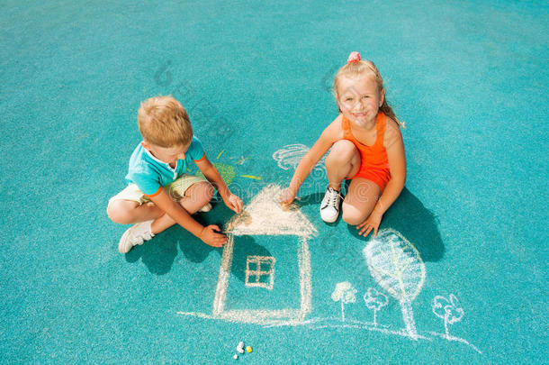 男孩和女孩坐着画粉笔图像