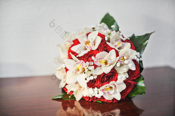 桌上摆着一束美丽的玫瑰花。婚礼上的一束红玫瑰。桌上摆着优雅的婚礼花束