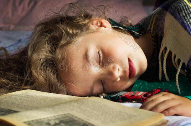 <strong>小卷发</strong>女学生睡在书上的特写肖像