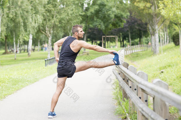运动型男子在运动前做伸展运动，户外运动。