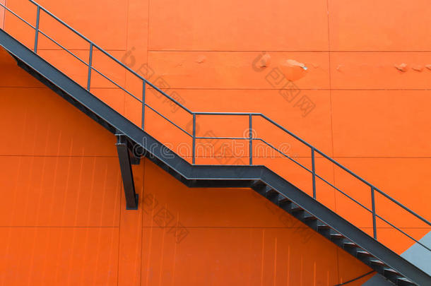 建筑物<strong>橙色墙面</strong>上的金属消防通道或紧急出口