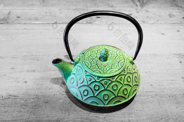 灰色木质背景的绿色茶壶