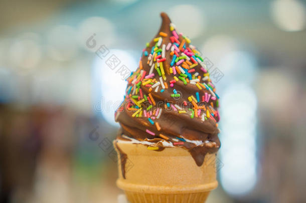 冰淇淋蛋卷巧克力和彩虹色洒在蓝色