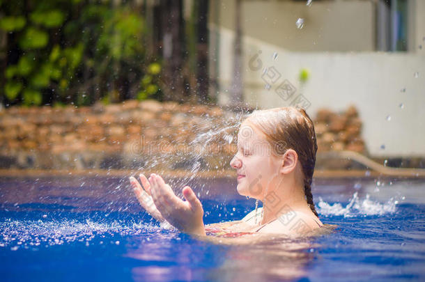 年轻女子在池水下放松放松淋浴水流到头部