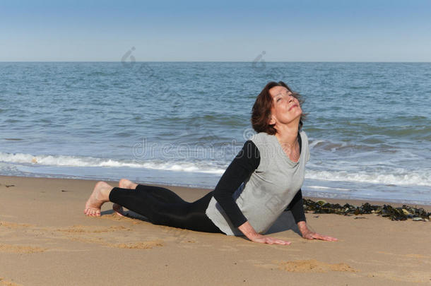 成熟的女人在沙滩上<strong>练瑜伽</strong>眼镜蛇