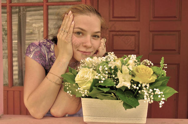 门廊上微笑的年轻女孩，开着一盆鲜艳的花
