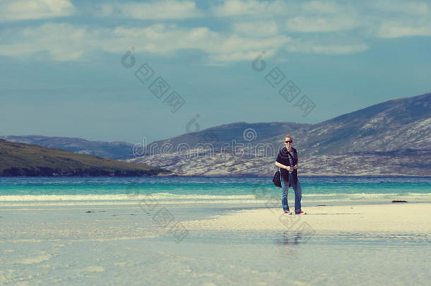 年轻的高加索女人在白沙滩上享受着绿宝石般的海水