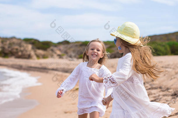可爱可爱的女孩在白色沙滩上玩得很开心