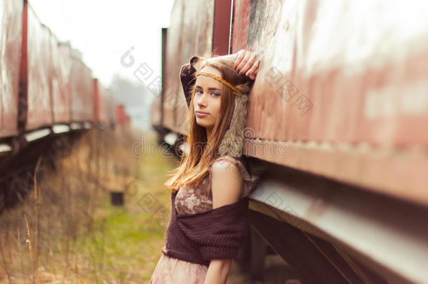 漂亮的嬉皮女孩，红头发，大嘴唇站在铁路附近的旧车附近