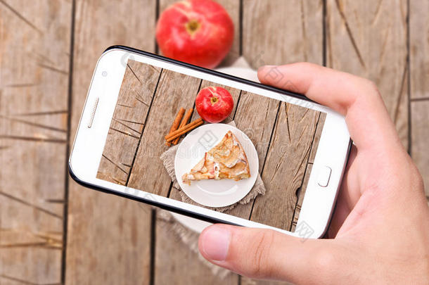 双手拍照苹果蛋糕与智能手机