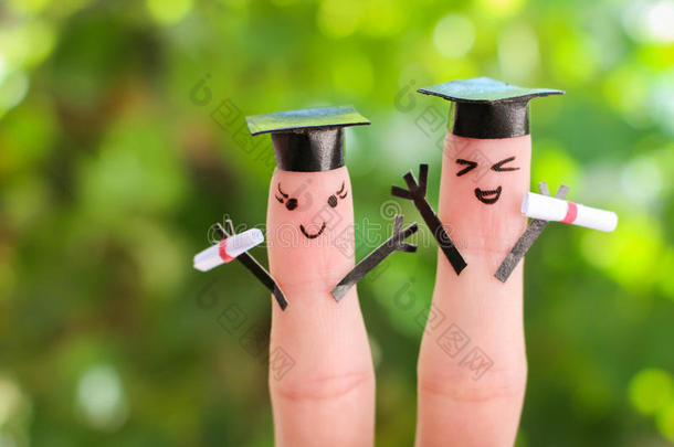 画在手指上的脸。毕业后持有毕业证书的学生